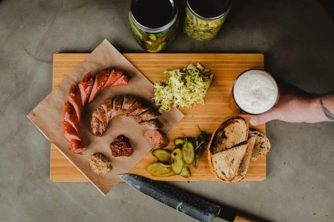A charcuterie board with a beer